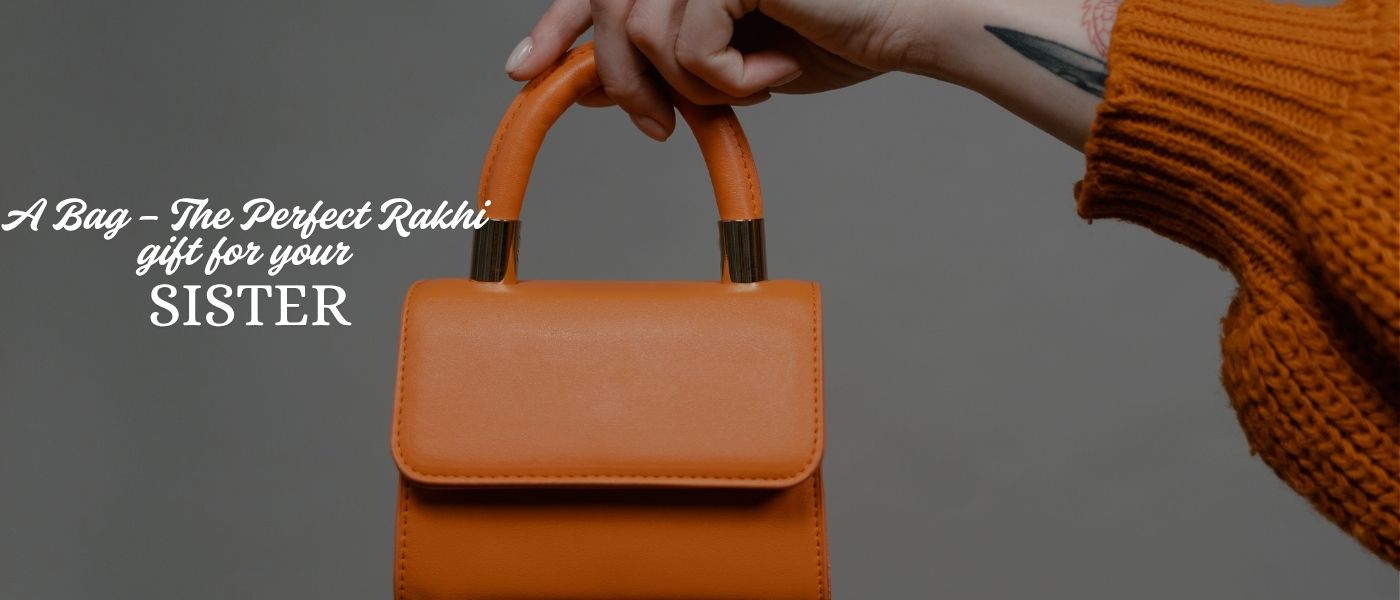 Hand holding an orange handbag