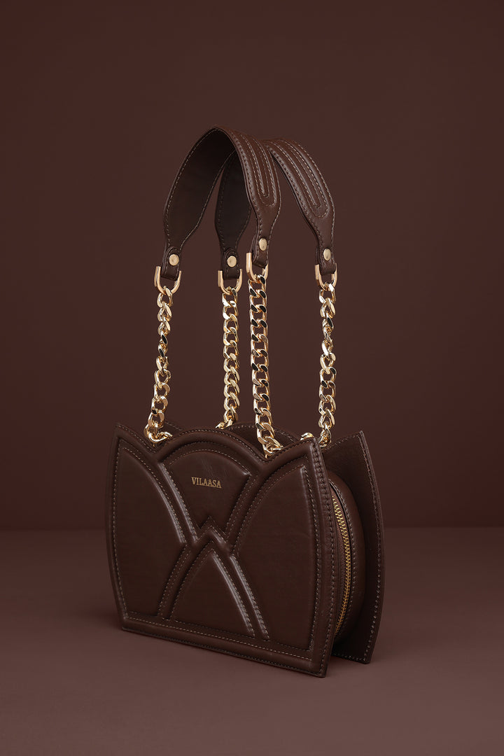 Brown Shoulder leather handbag with gold chain strap on a brown background
